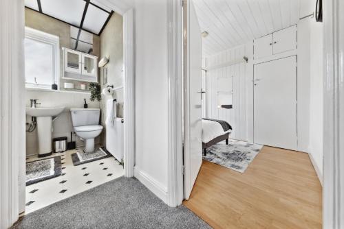 a bathroom with a toilet and a sink at Quincy's Homes in Dartford