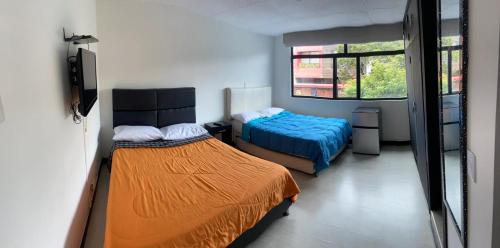 a bedroom with two beds and a window at casabosque habitacion301 in Bogotá