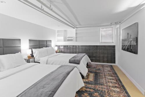 a bedroom with two beds and a rug at 20 Mins to Times Sq. EWR | Cozy Apartment | Sleeps 4 in Jersey City