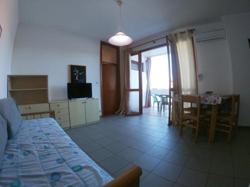 ein Schlafzimmer mit Bett und ein Esszimmer mit Tisch in der Unterkunft Apartment in Rosolina Mare 34042 in Rosapineta
