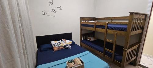 a bedroom with two bunk beds with blue sheets at Pousada House Beach 2 - BRASIL - Aviação in Praia Grande