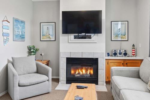 a living room with a fireplace and a tv at Coastal Cutie in Oceano