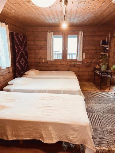 a bedroom with two beds in a log cabin at 海を眺めるログハウス カマカーマAwaji in Awaji