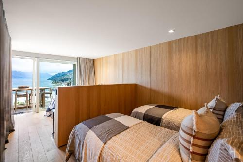 ein Hotelzimmer mit zwei Betten und Balkon in der Unterkunft Luxury Away - Manaia Views-HotTub-FreeParking-BBQ in Queenstown