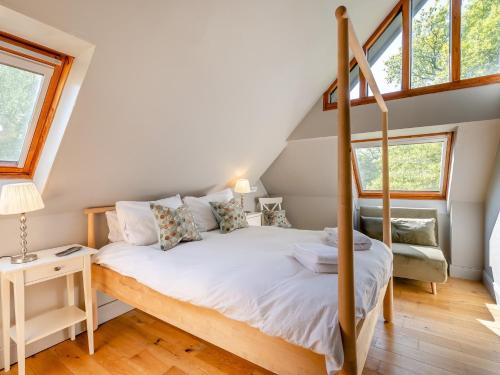 ein Schlafzimmer mit einem Bett in einem Zimmer mit Fenstern in der Unterkunft 8 Bed in Crowborough 92858 in Crowborough