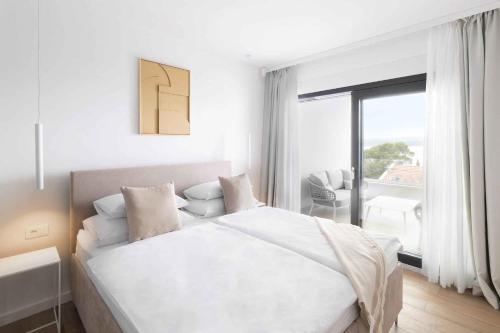 ein weißes Schlafzimmer mit Bett und Balkon in der Unterkunft Holiday home in Dramalj 45043 in Dramalj