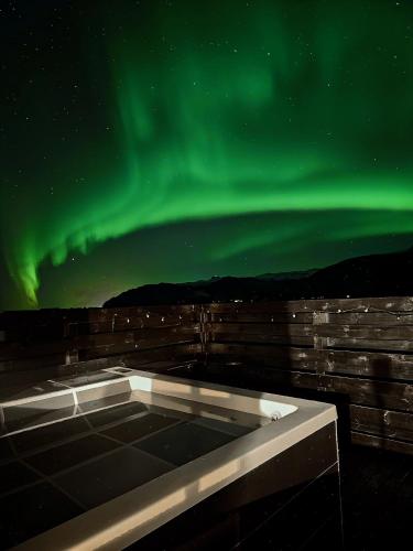 an outdoor hot tub under the aurora borealis at Aurora Cabin and Private Jacuzzi in Hvolsvöllur