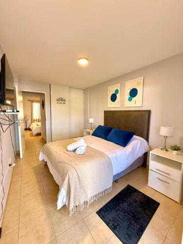 a bedroom with a large bed with blue pillows at Paramont Rosario 3 in Rosario de la Frontera