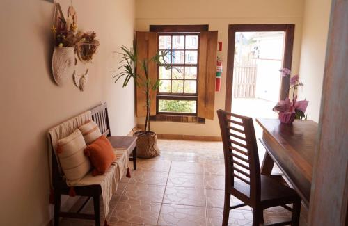 a living room with a table and a couch at Recanto das Libélulas Pousada in Tiradentes