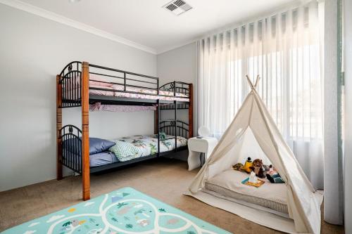 a childrens bedroom with bunk beds and a play area at Modern Bassendean Abode in Perth