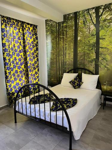 a bedroom with a bed with two paintings on the wall at une chambre dépaysante in Tarrafal