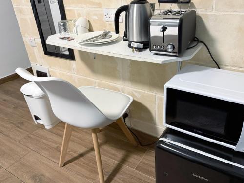 een tafel met een witte stoel en een magnetron bij Mini Studios in Central Victoria in Victoria
