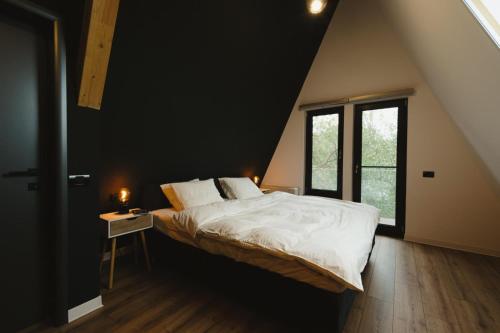 a bedroom with a large bed and a window at Domaine A Chalet in Malu Roşu