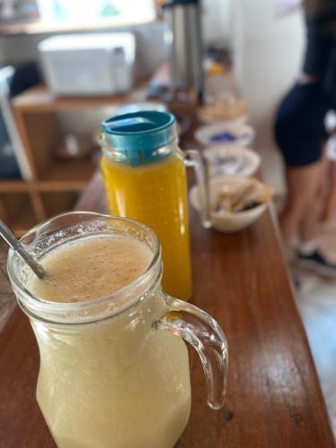 Un frasco de vidrio con líquido amarillo sobre una mesa de madera. en Suíte na Flor de Debora, en Alto Paraíso de Goiás
