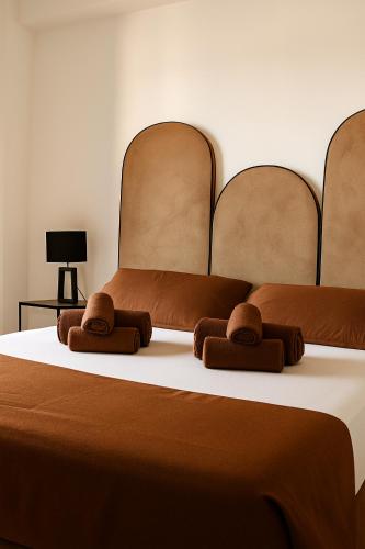two beds with brown blankets and brown towels on a bed at Marisabella Suite Spa 5 in Bari