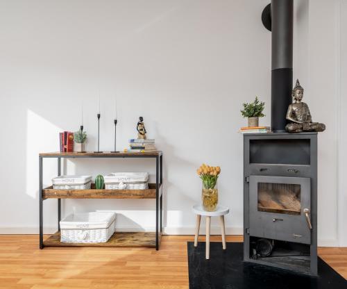 Una chimenea en una sala de estar con una mesa y un estante. en Nice 65m2 apartment in central Dachau, en Dachau
