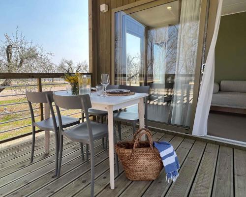 コラ・ディ・ラツィーゼにあるMobilehome in Lazise - Gardasee 45718の窓のあるデッキ(白いテーブル、椅子付)