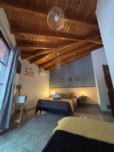 a bedroom with two beds and a wooden ceiling at Hotel Alta Mendoza in Mendoza