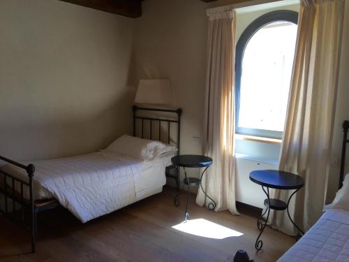 a bedroom with a bed and two tables and a window at Locanda Palazzone in Orvieto