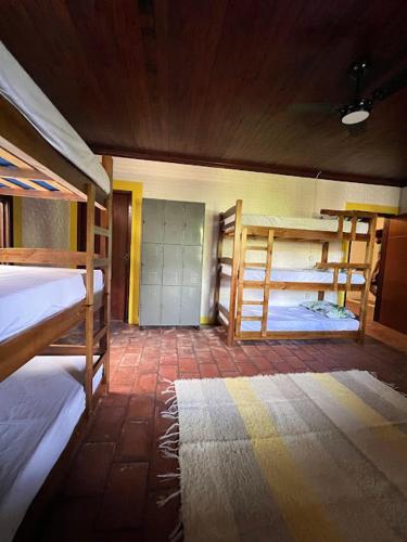 a room with two bunk beds and a hallway at Tô Zen Hostel in Ubatuba