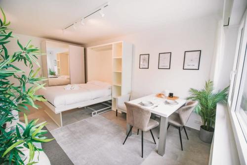 een slaapkamer met een bed, een tafel en stoelen bij Stylish Studio in the Heart of Luxembourg City in Luxemburg