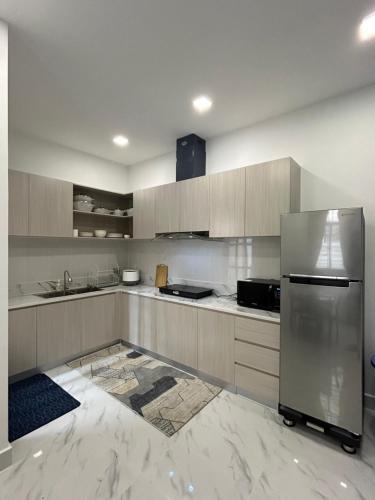 a kitchen with a stainless steel refrigerator and cabinets at Charming 4-bedroom townhome in vibrant Phnom Penh! in Phnom Penh