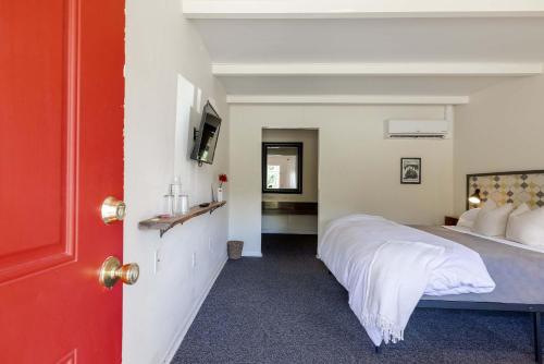 a bedroom with a large bed and a red door at The Billy Motel King Room with Retro Charm in Davis