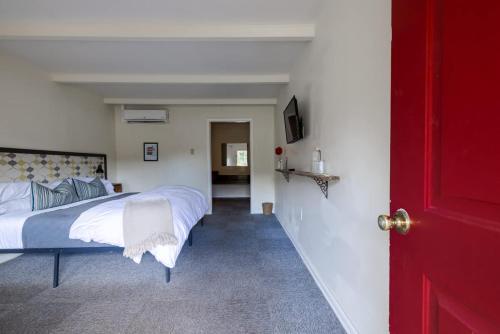 a bedroom with a bed and a red door at The Billy Motel Pet Friendly Room with Charm in Davis