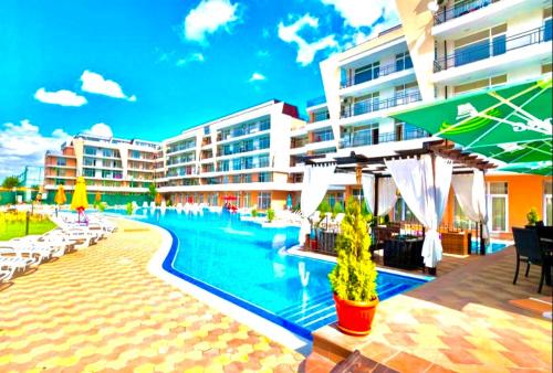 una piscina junto a un complejo turístico con edificios en Grand Kamelia apartments, en Sunny Beach