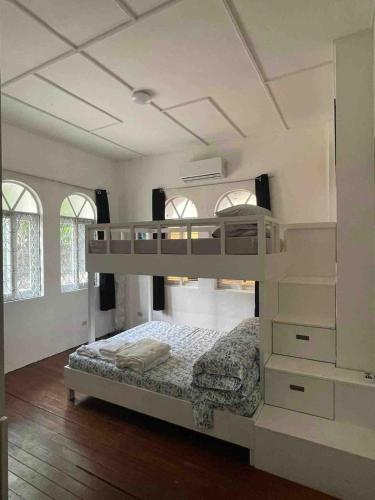 a white bedroom with a bunk bed in it at Big Beautiful House in Pasig in Manila