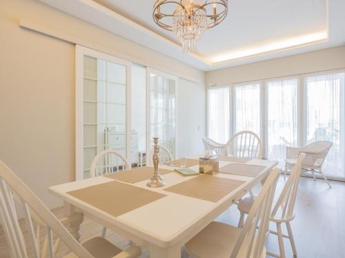 uma sala de jantar com uma mesa branca e cadeiras em White Truffle B&B em Luodong