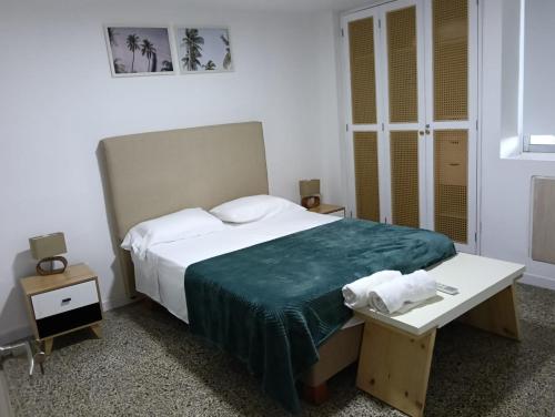 a bedroom with a large bed with a green blanket at Toscana Suite 2 D in Estación El Salto