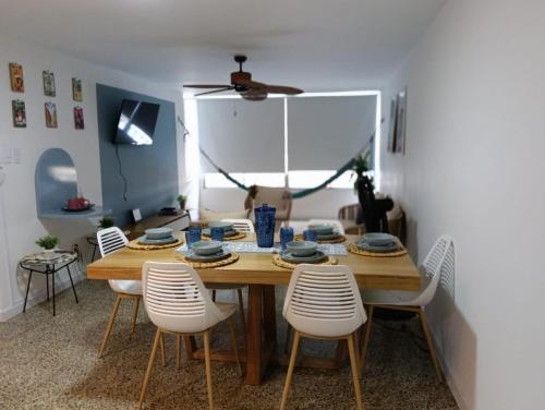 a dining room with a wooden table and white chairs at Toscana Suite 2 D in Estación El Salto