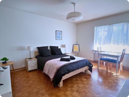 Un dormitorio con una cama, una mesa y un escritorio. en HSH Flur Inn, en Berna