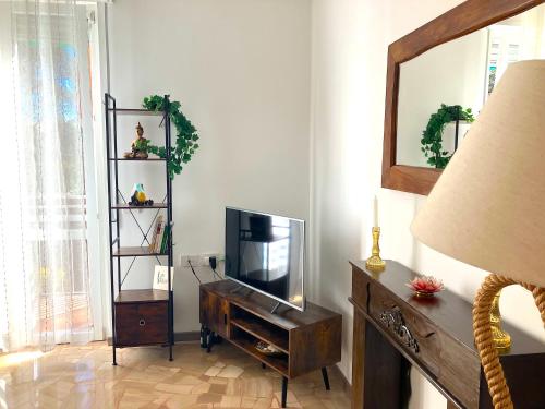 a living room with a tv on a wooden dresser at Charming king studio with balcony and jacuzzi in Como