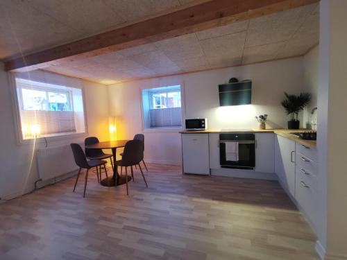 a kitchen and dining room with a table and chairs at Seperat lejlighed i stueetage in Sisimiut