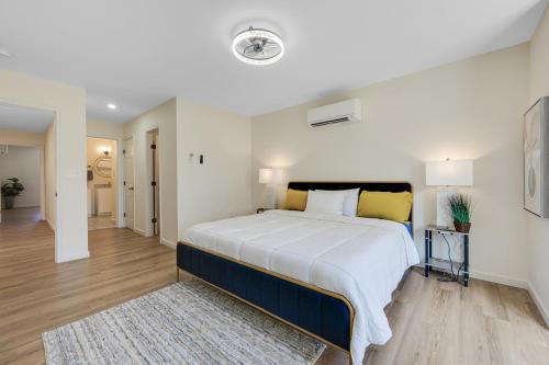 a large white bedroom with a large bed with yellow pillows at Elegant 2 Story Bloomfield 3 Kings 2 Queens in Bloomfield