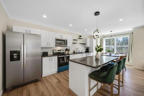 a kitchen with white cabinets and a stainless steel refrigerator at Elegant 2 Story Bloomfield 3 Kings 2 Queens in Bloomfield