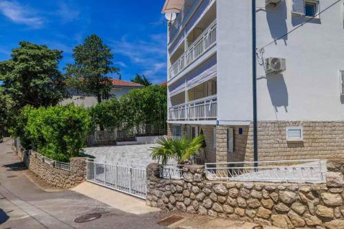 a building with a stone wall next to a street at Apartments in Dramalj 39393 in Dramalj
