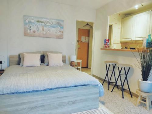 a bedroom with a bed and a kitchen at Cocon lumineux à Bandol à deux pas de la plage et de la gare in Bandol