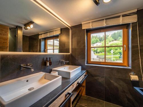 Un baño con lavabo y ventana. en Fernblick, en Kirchberg in Tirol