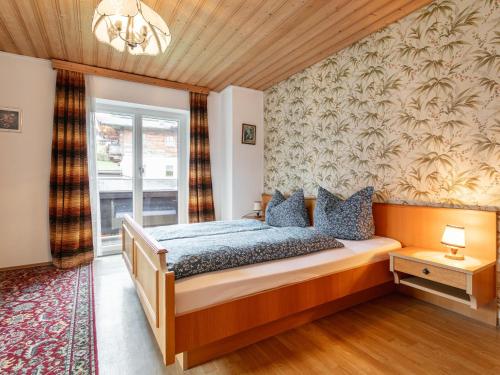 Un dormitorio con una cama con almohadas azules. en Landhaus am Waldrand, en Oberndorf in Tirol