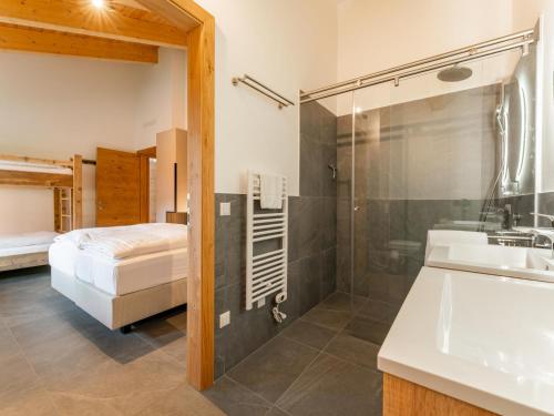 een badkamer met douche en wastafel en een bed bij Grebenzen Lodge Starnberg 60B in Sankt Lambrecht