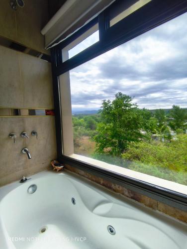 a bath tub in front of a window with a view at MIracampo in San Antonio de Arredondo
