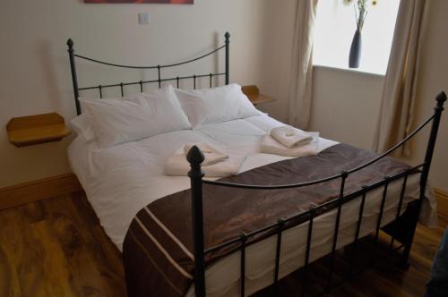 1 dormitorio con 1 cama con sábanas y almohadas blancas en Sea Breeze Guest House, en Douglas