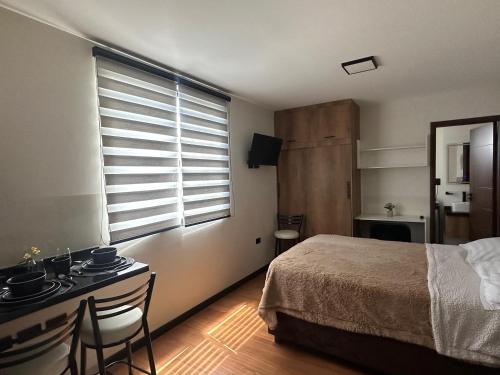 um quarto com uma cama, uma escrivaninha e uma janela em Monoambiente moderno y ubicación ideal em Cochabamba