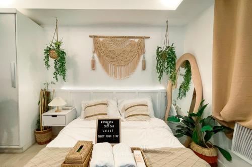 a bedroom with a bed with plants on the wall at Cozy Oak - Boho Studio for Couples with Huge Balcony in San Fernando