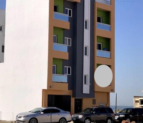 RufisqueにあるRufisqueの建物の前に駐車した車両2台