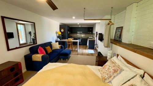 a living room with a bed and a kitchen at Koala Cottage in Leongatha