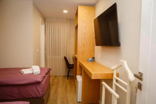 a small hotel room with a bed and a desk at Hermes Petite Maison Hotel in Tirana